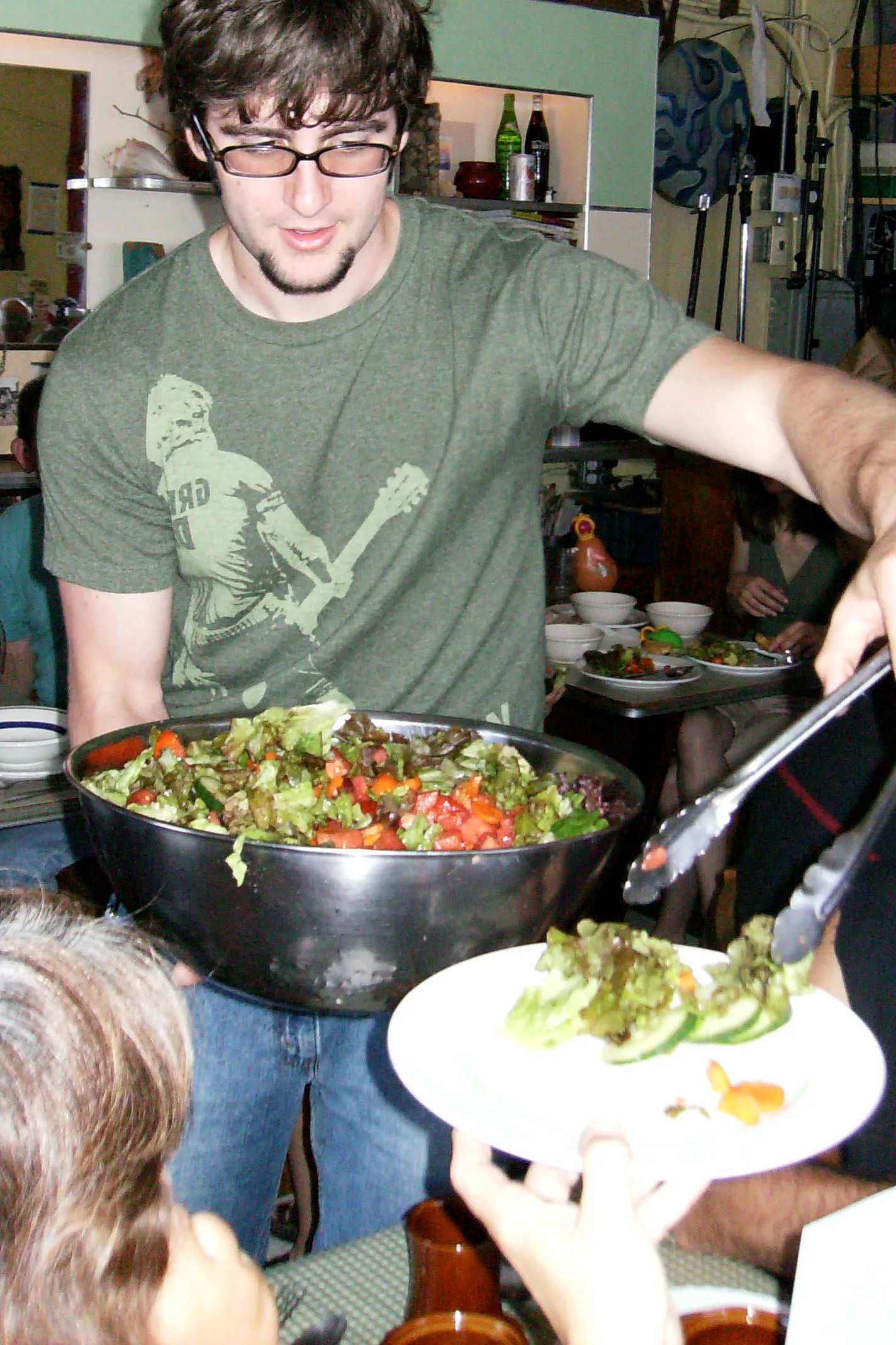Beispielbild, keine Aufnahme von Chico: bei einer Essensausgabe wird Salat aus einer großen Schüssel auf einen Teller gefüllt, den jemand hinhält
